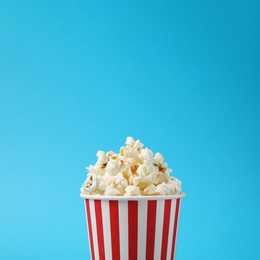 Photo of Delicious popcorn on light blue background, closeup
