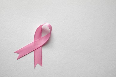 Photo of Pink ribbon on white background, top view with space for text. Breast cancer awareness concept