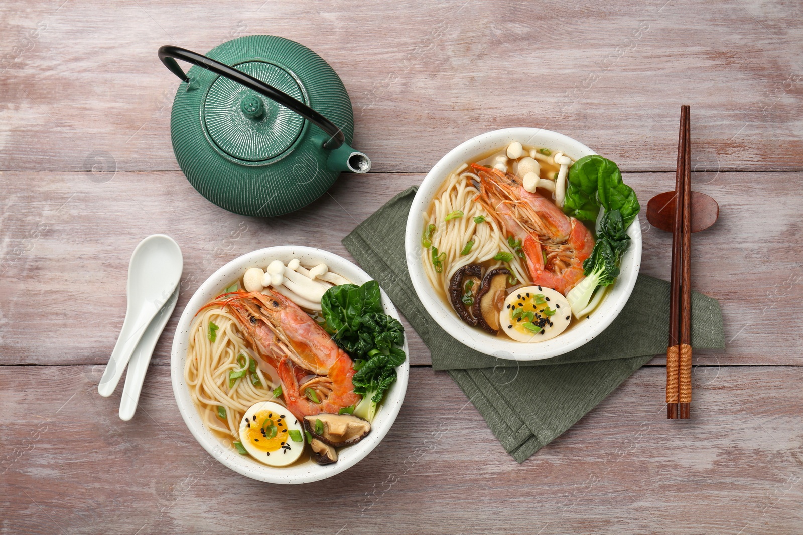 Photo of Delicious ramen with shrimps in bowls served on wooden table, flat lay. Noodle soup