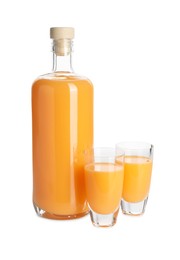 Photo of Bottle and shot glasses with tasty tangerine liqueur isolated on white