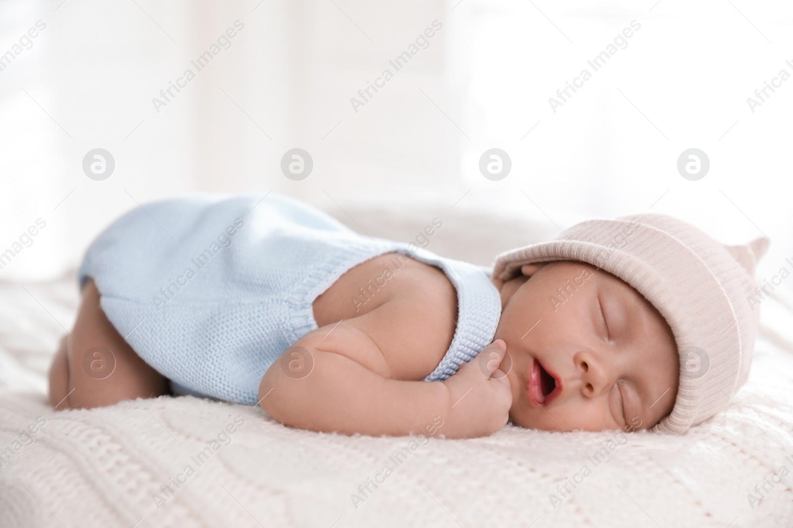 Photo of Adorable newborn baby sleeping on white knitted plaid