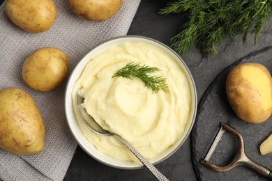 Freshly cooked homemade mashed potatoes and raw ingredients on black table, flat lay