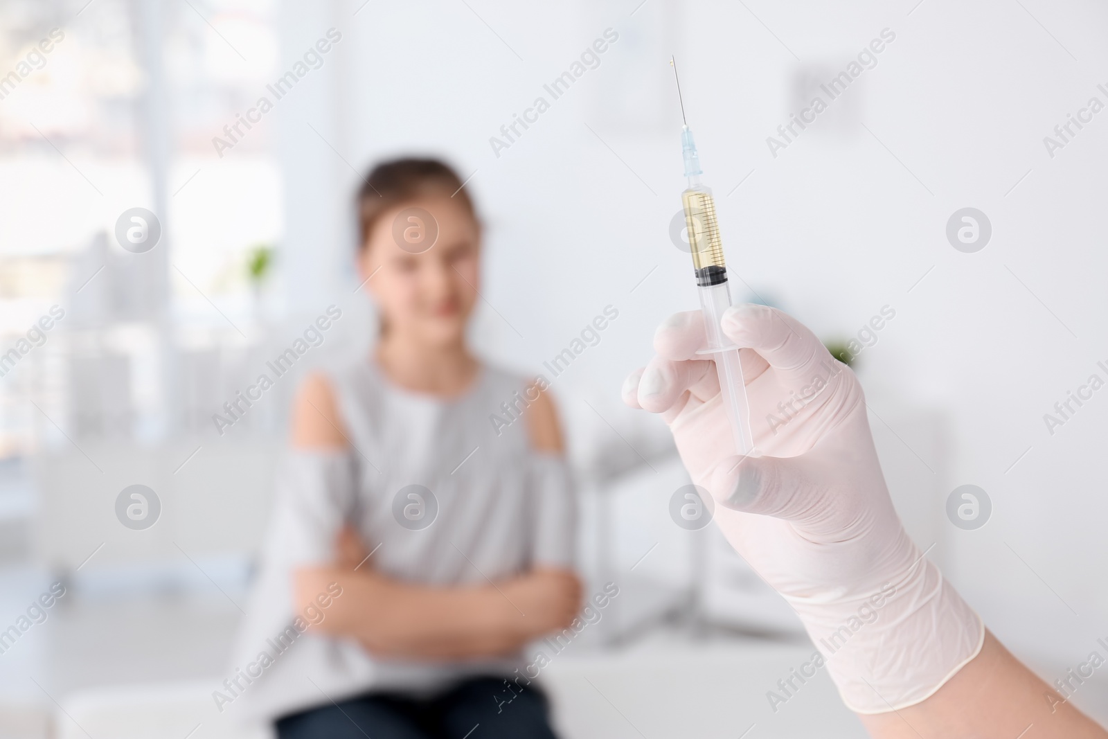 Photo of Doctor with syringe and child on background. Vaccination day