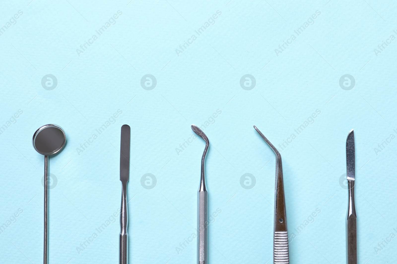 Photo of Different dentist's tools on light background, flat lay. Space for text