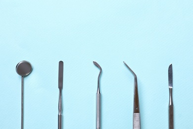Different dentist's tools on light background, flat lay. Space for text