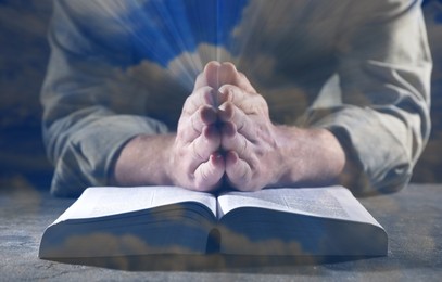 Religion. Double exposure of sky and Christian man praying over Bible at table, closeup