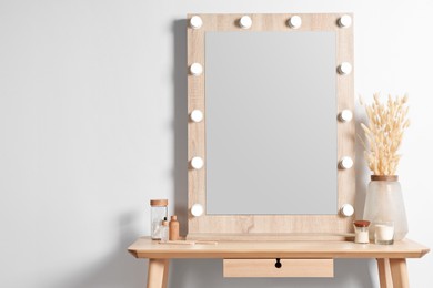 Dressing table with stylish mirror, dried reeds and other decorative elements. Interior design