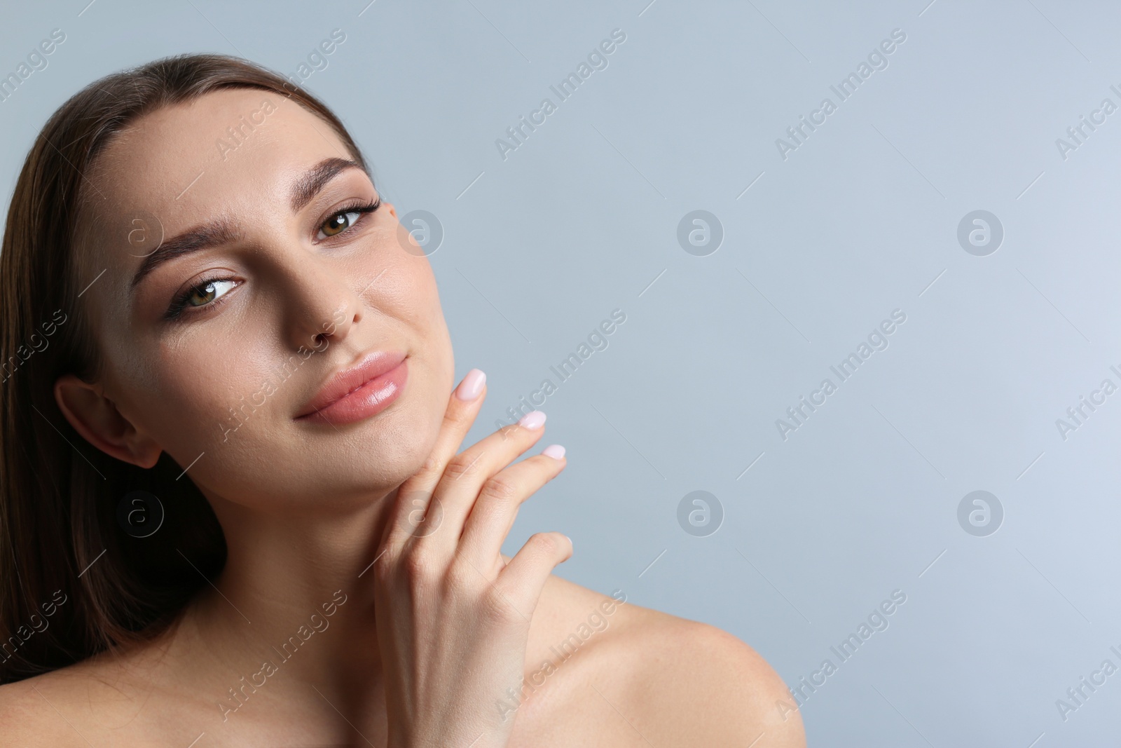 Photo of Portrait of beautiful young woman with plump lips on light grey background. Space for text