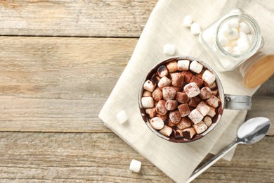 Photo of Delicious hot chocolate with marshmallows and cocoa powder in cup on wooden table, flat lay. Space for text