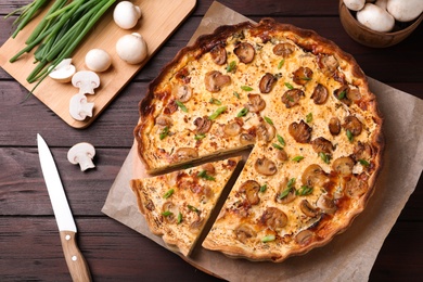 Photo of Delicious pie with mushrooms and cheese on brown wooden table