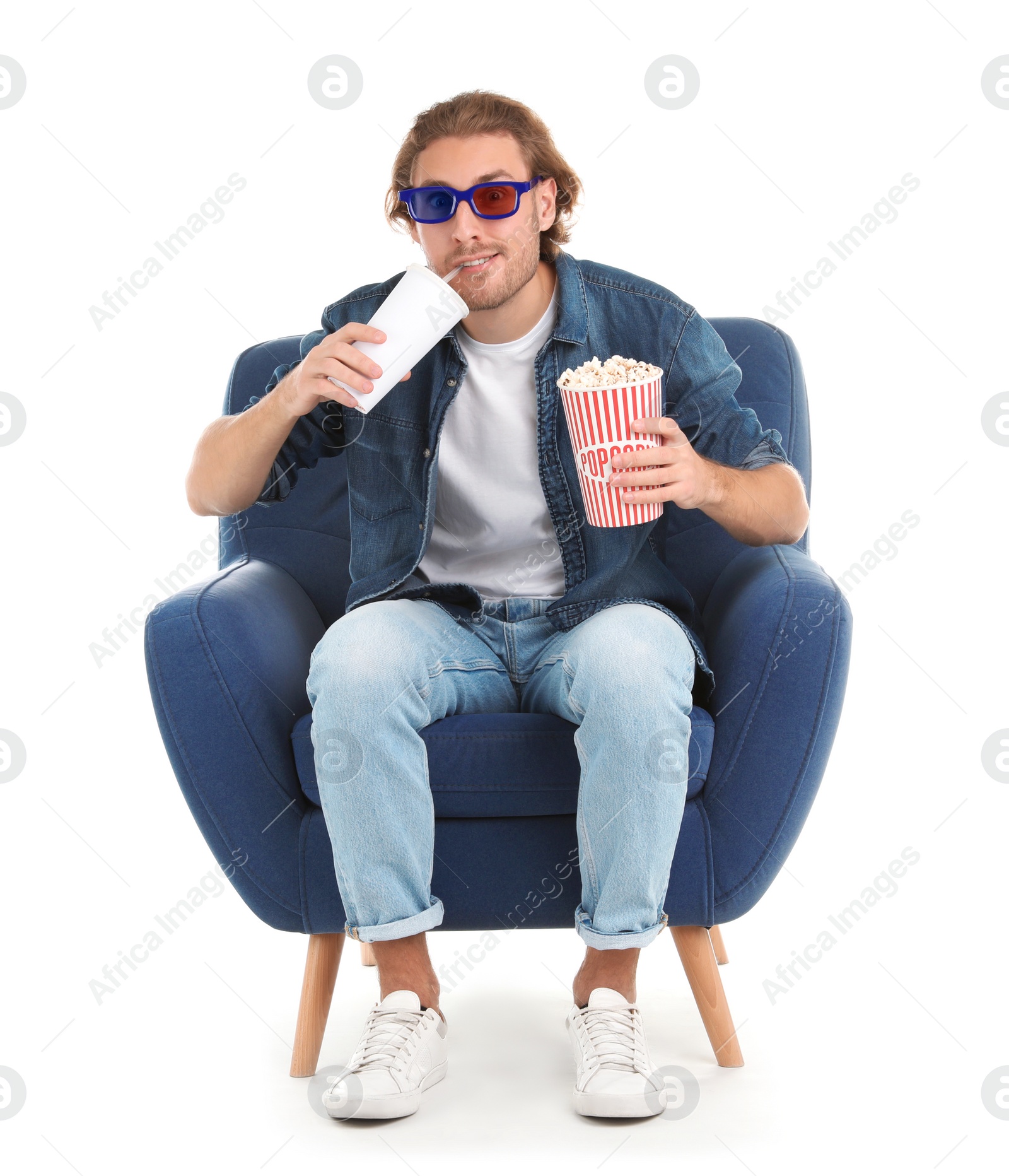 Photo of Man with 3D glasses, popcorn and beverage sitting in armchair during cinema show on white background