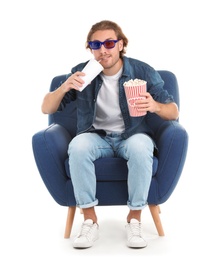 Man with 3D glasses, popcorn and beverage sitting in armchair during cinema show on white background
