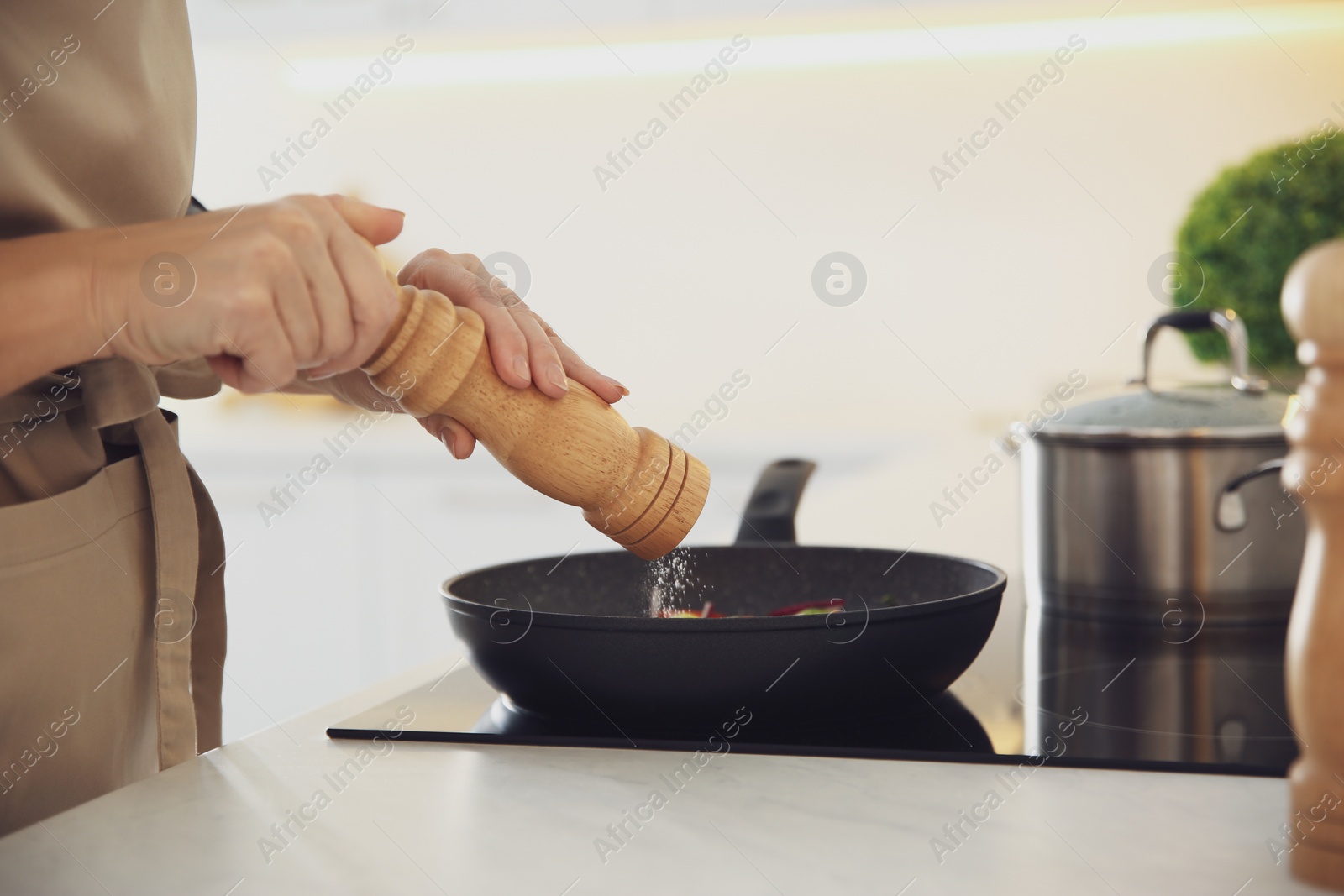 Photo of Woman cooking on stove in kitchen, closeup