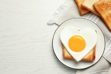 Photo of Tasty fried egg in shape of heart with toasts on white wooden table, flat lay. Space for text