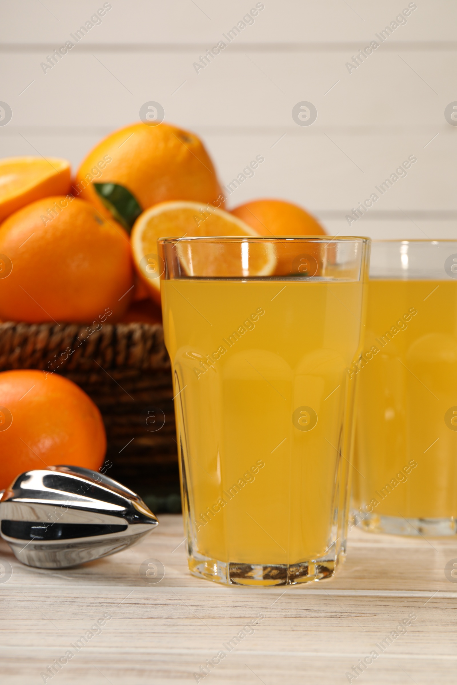 Photo of Tasty freshly made orange juice on white wooden table