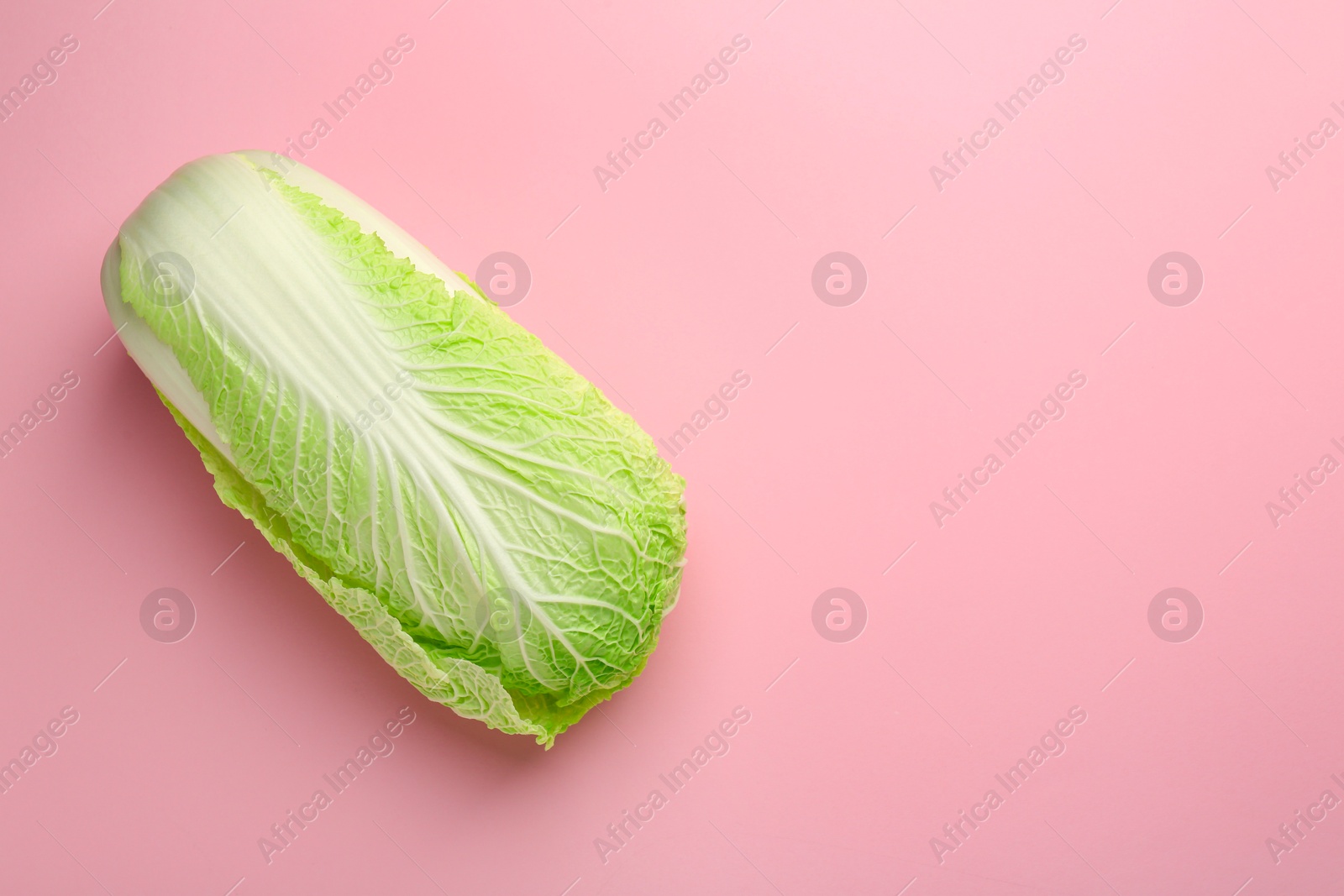 Photo of Fresh ripe Chinese cabbage on pink background, top view. Space for text