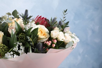 Beautiful bouquet with roses on light blue background, closeup