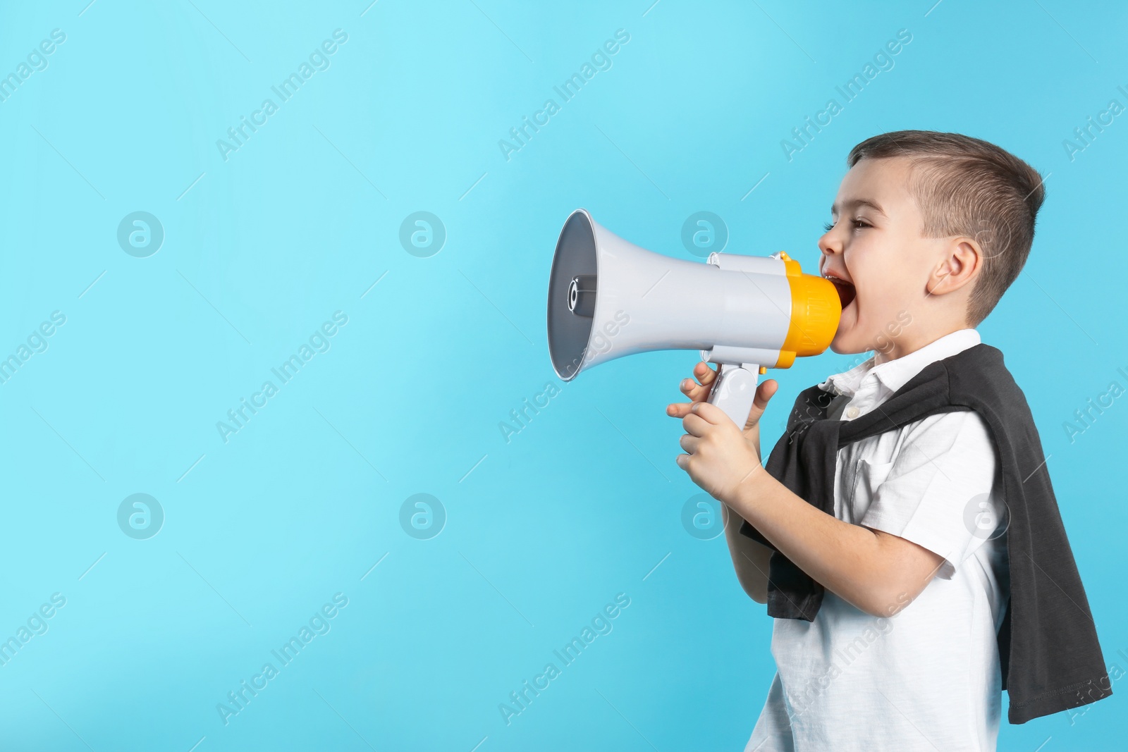 Photo of Cute funny boy with megaphone on color background. Space for text