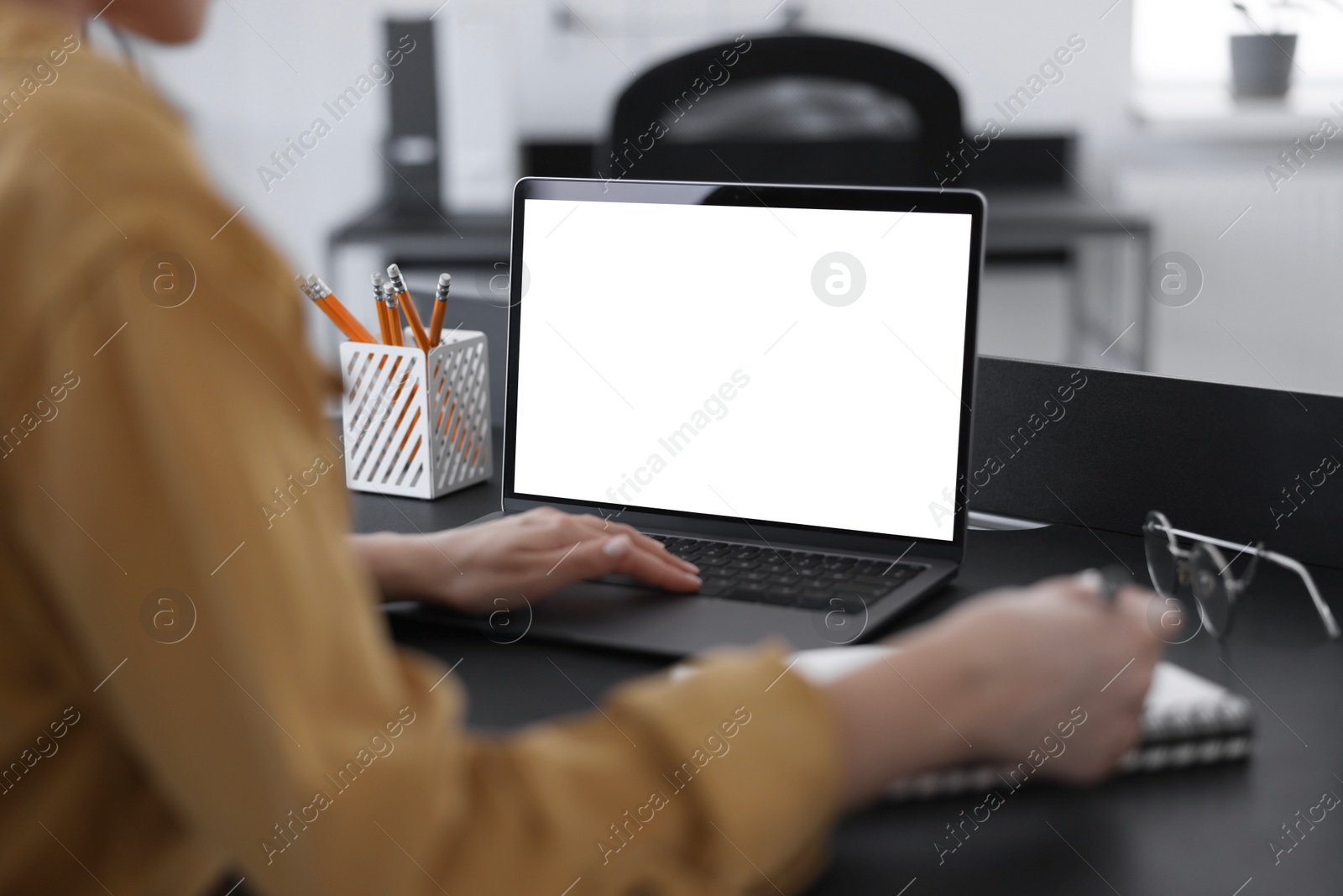 Photo of Woman taking notes during webinar at table indoors, closeup