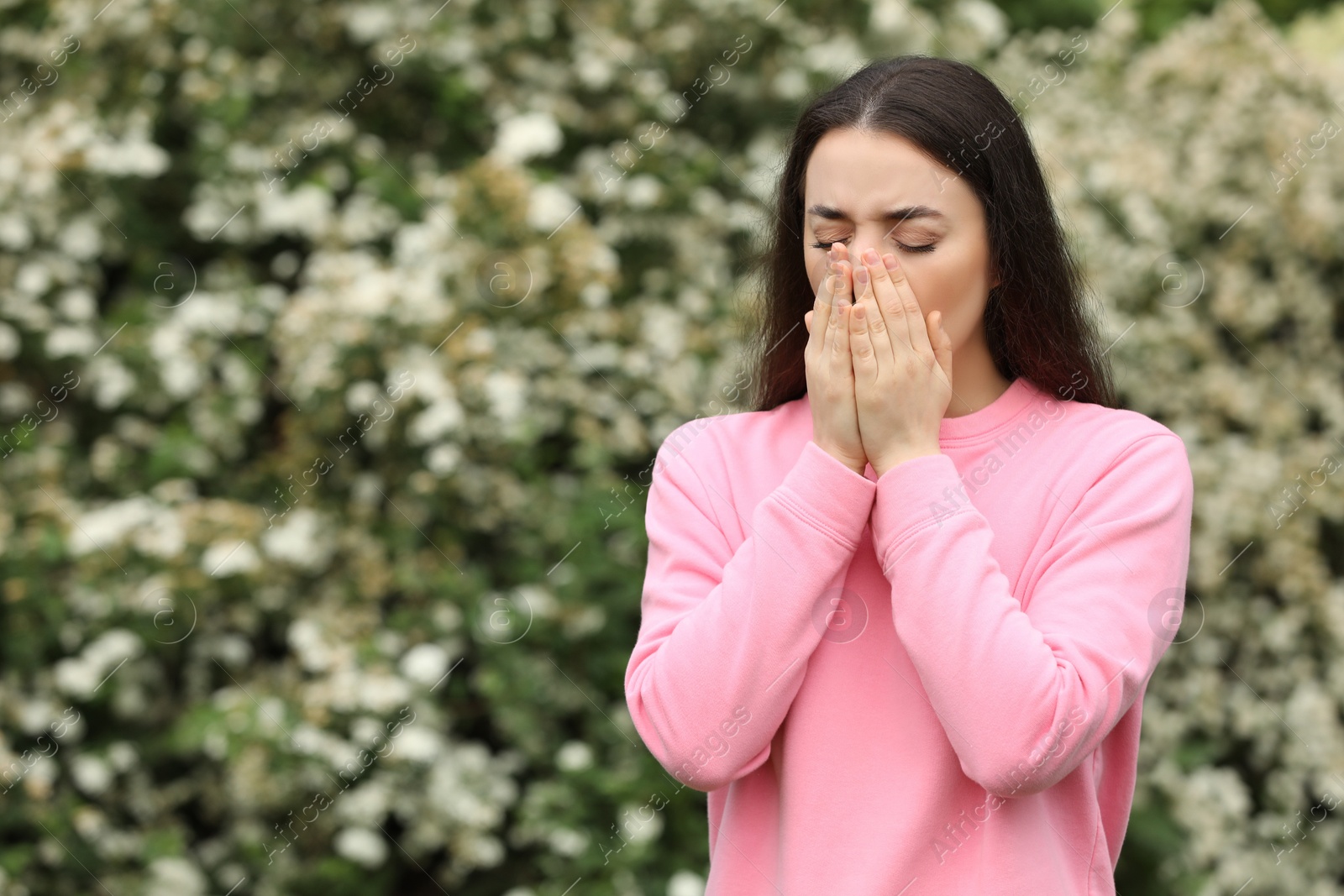 Photo of Woman suffering from seasonal spring allergy outdoors, space for text