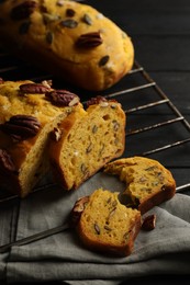 Photo of Delicious pumpkin bread with pecan nuts on black wooden table, closeup