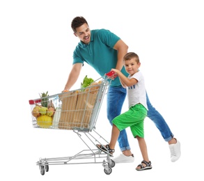 Father and son with full shopping cart on white background