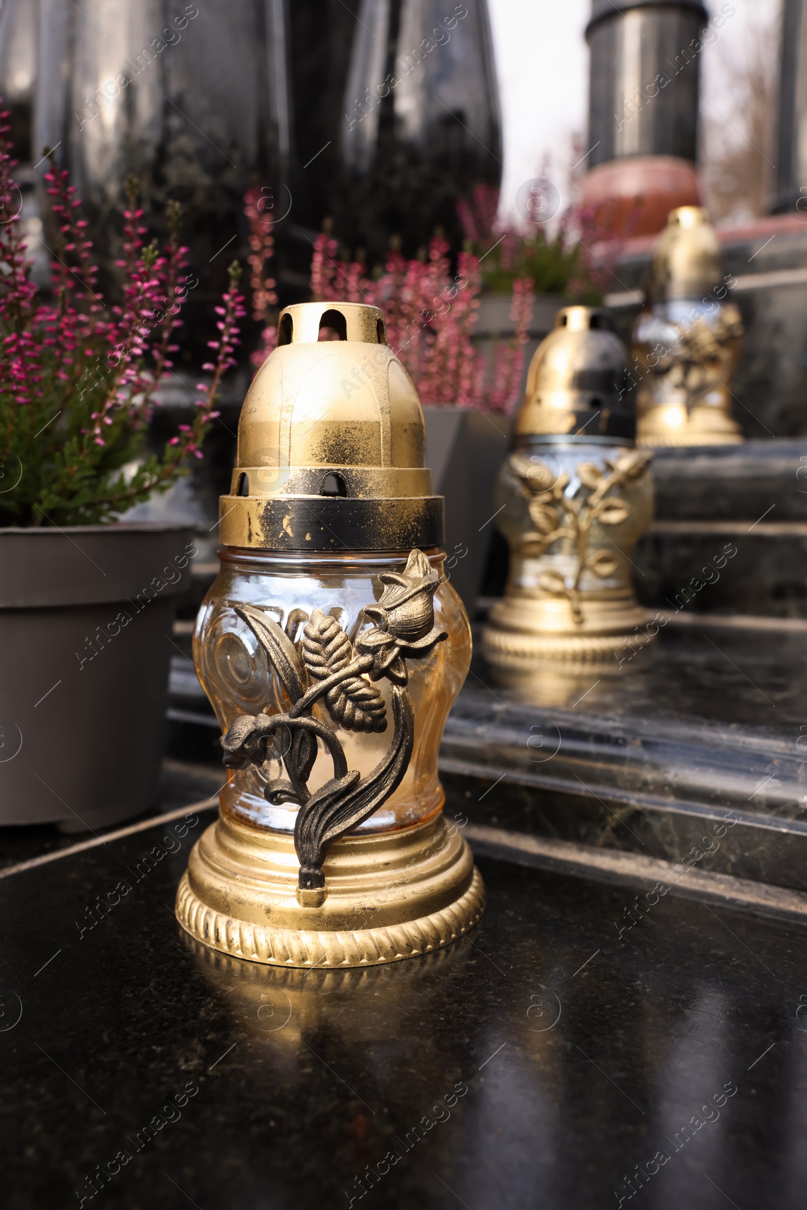 Photo of Grave lanterns on black tiled surface at cemetery