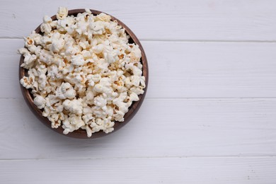 Tasty popcorn on white wooden table, top view. Space for text