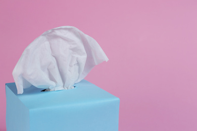 Photo of Box with paper tissues on pink background, closeup. Space for text