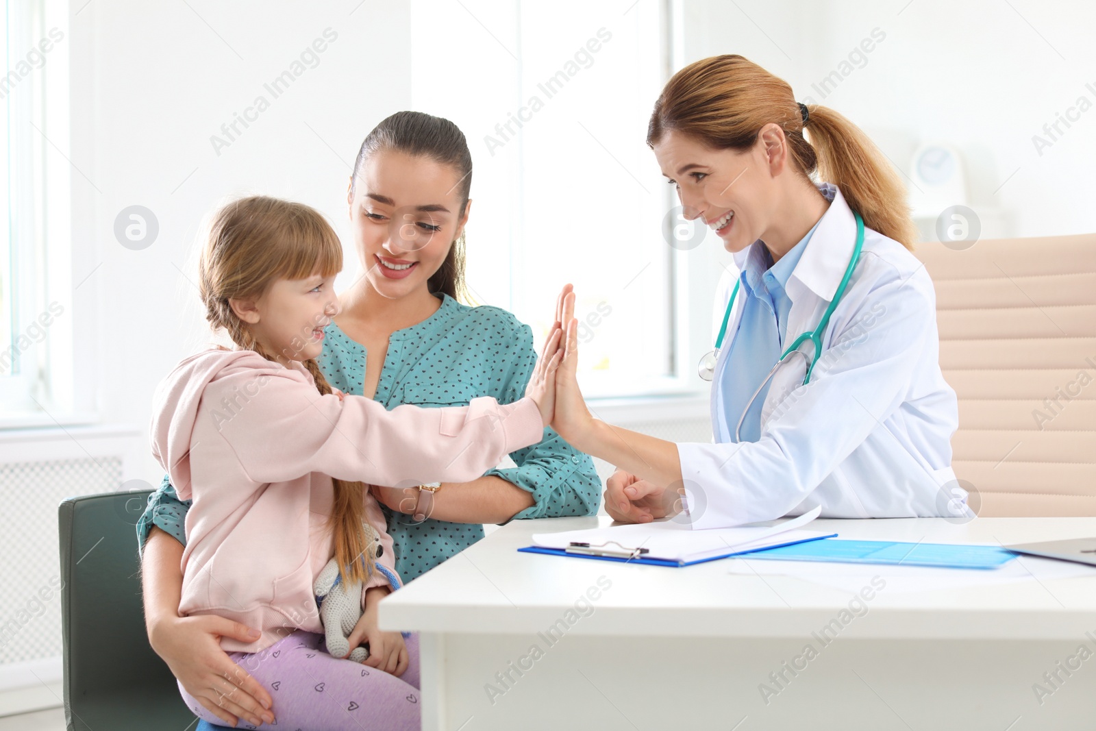 Photo of Little girl with parent visiting children's doctor in hospital