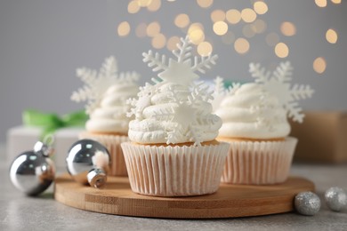 Photo of Tasty Christmas cupcakes with snowflakes on grey table