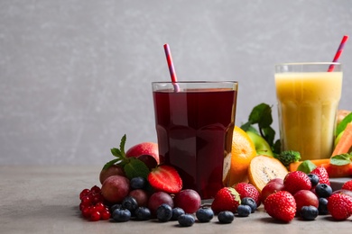 Photo of Delicious juice and fresh ingredients on grey table. Space for text