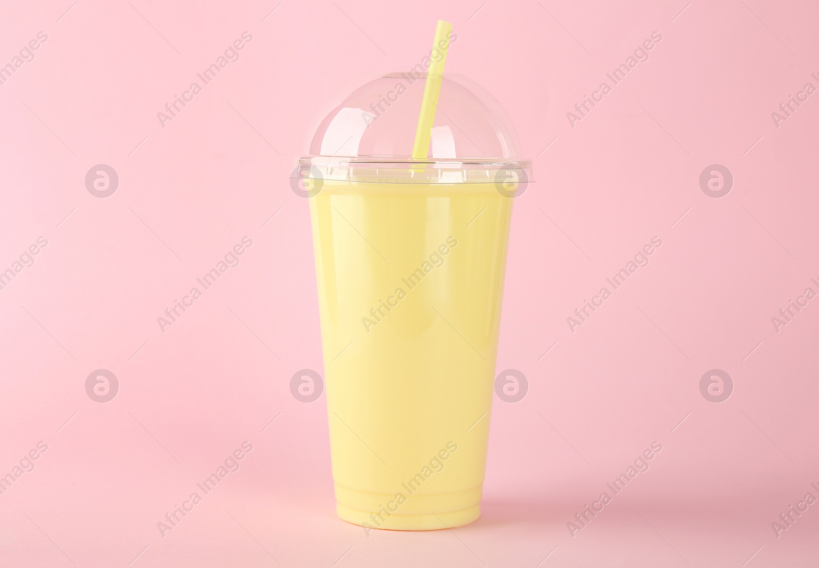 Photo of Plastic cup of tasty smoothie on pink background