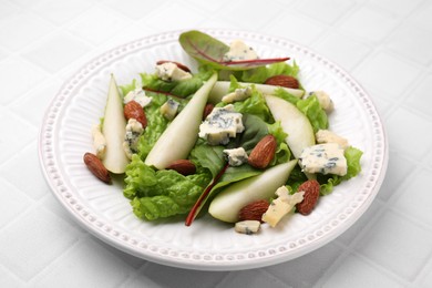 Photo of Delicious pear salad on white tiled table, closeup