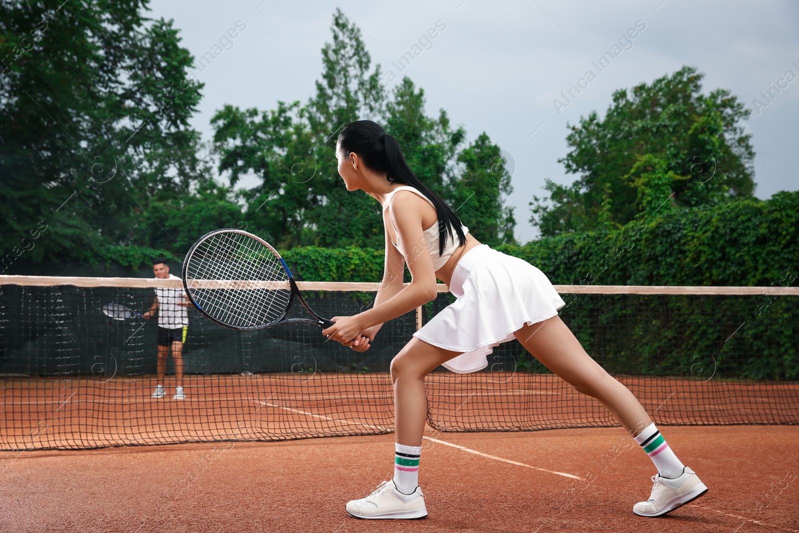 Photo of Man and woman playing tennis on court