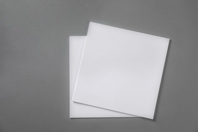Photo of Stack of blank paper sheets for brochure on light grey background, top view