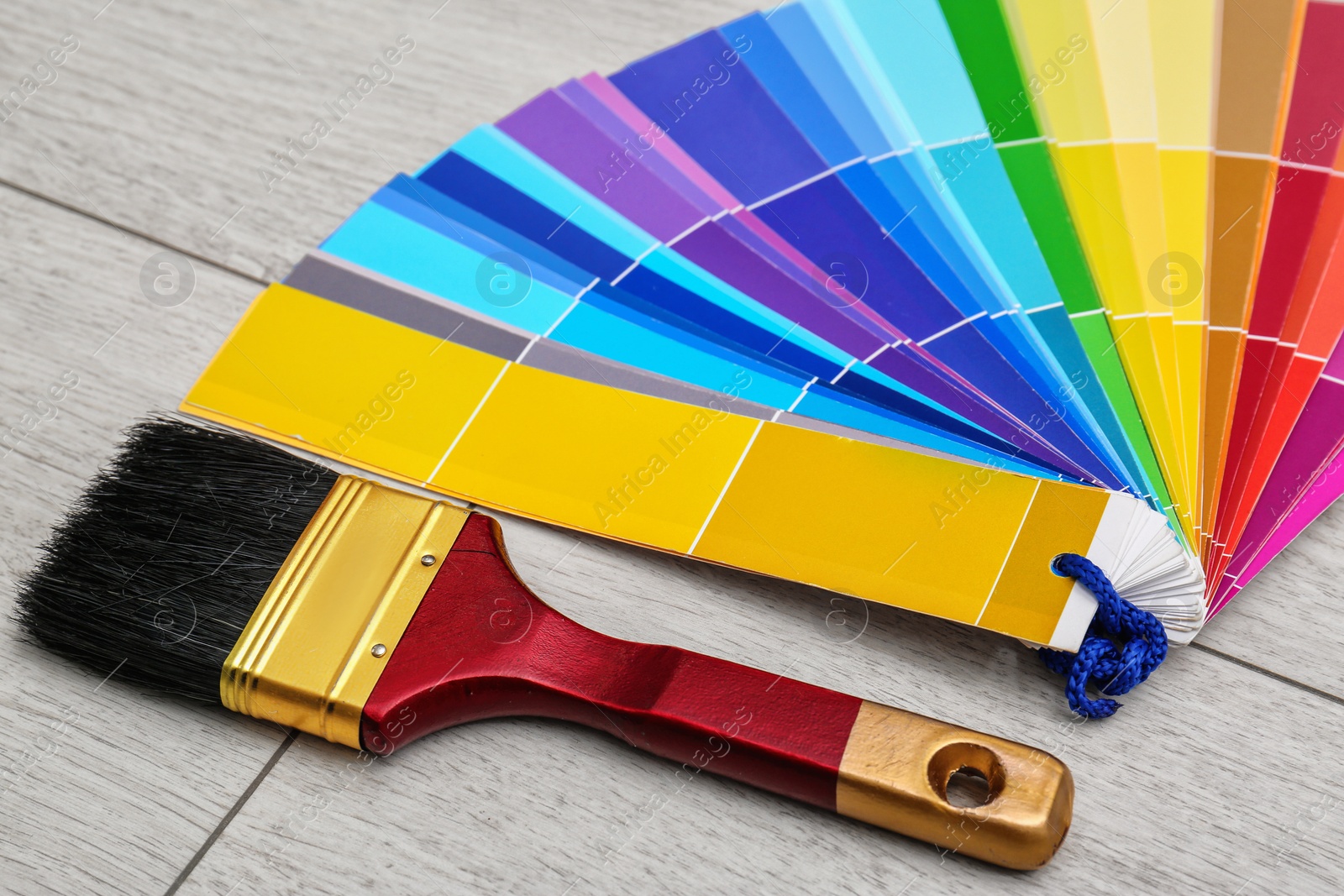 Photo of Paint brush and color palette samples for interior decorating on floor