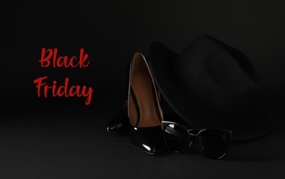 Photo of Phrase Black Friday, women's shoes, sunglasses and hat on dark background