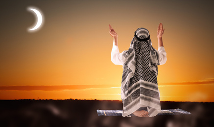 Image of Muslim man in traditional clothes praying outdoors. Holy month of Ramadan