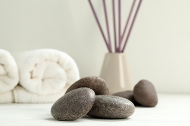 Photo of Pile of spa stones on white wooden table, closeup