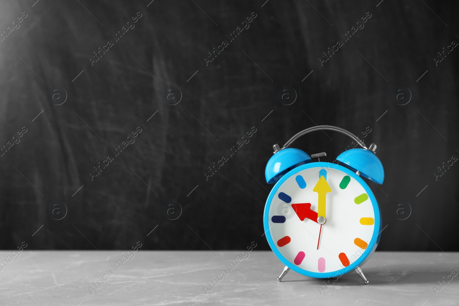 Photo of Alarm clock on table against color background. Time concept