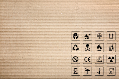 Image of Cardboard box with packaging symbols as background, closeup