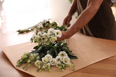 Photo of Florist making beautiful bouquet in workshop, closeup