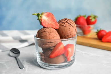 Glass of chocolate ice cream with strawberry on grey table