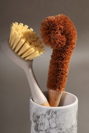 Cleaning brushes in holder on grey background, closeup