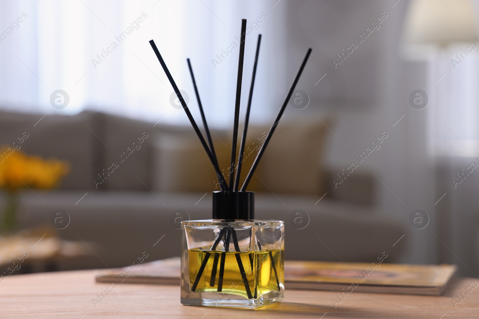 Photo of Reed diffuser on wooden table indoors. Cozy atmosphere