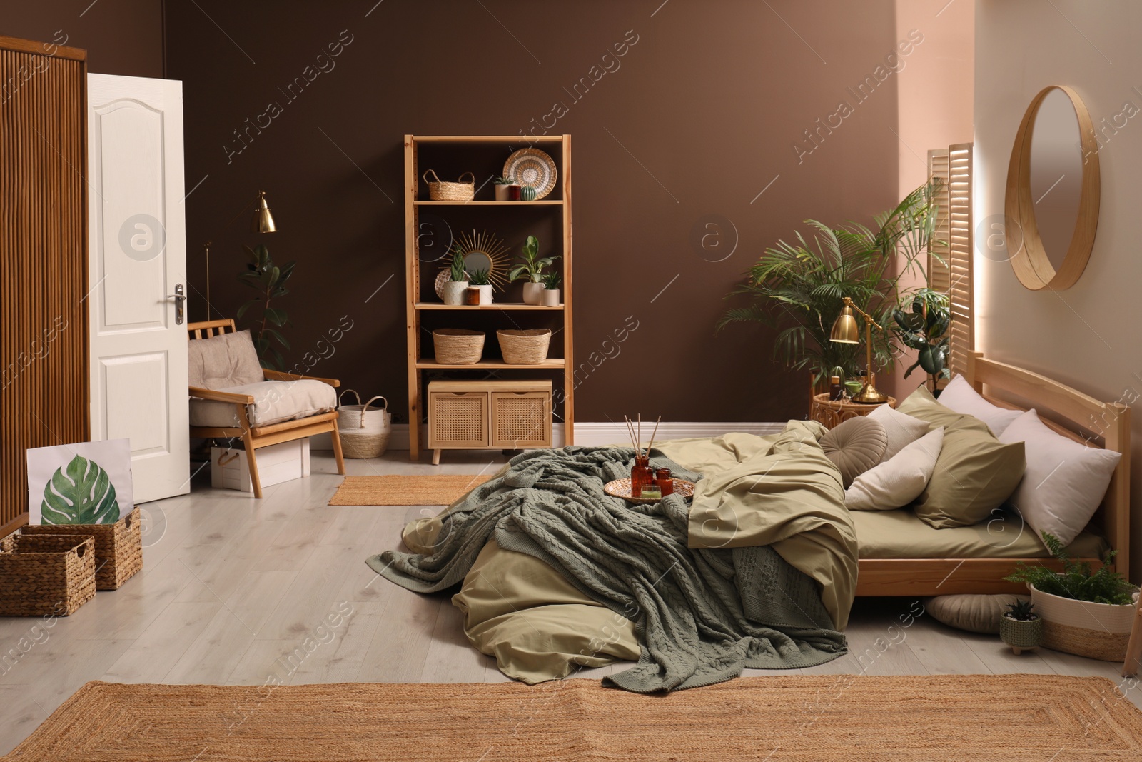 Photo of Stylish interior with large comfortable bed and potted plants