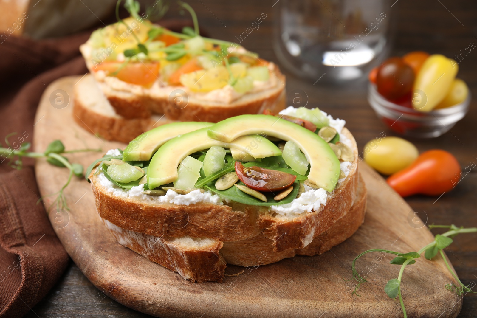 Photo of Tasty vegan sandwiches with vegetables on wooden table, closeup