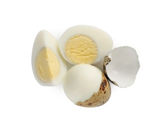 Peeled hard boiled quail eggs and another one partly in shell on white background, top view