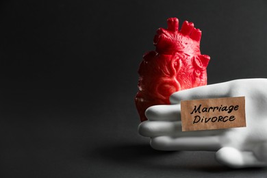 Photo of Modelheart, decorative hand and card with words Marriage Divorce on black background, space for text